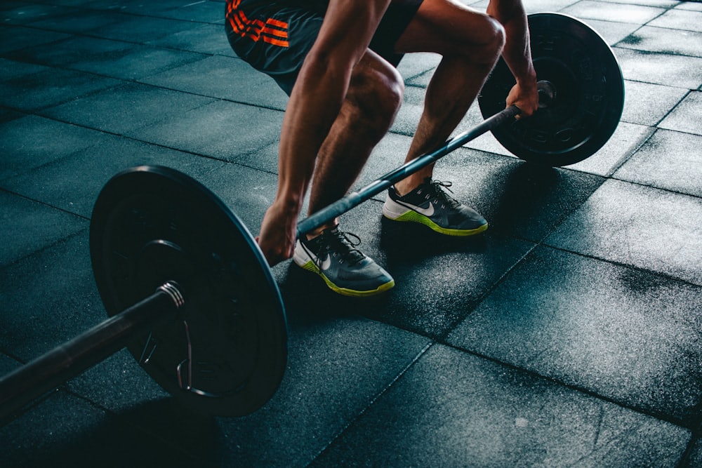 Sportiv pregătindu-se pentru un deadlift cu haltera într-o sală întunecată